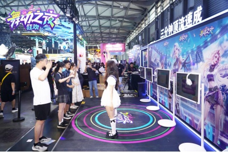玩家积极参与宅舞教学/领跳，笑容灿烂，展台前人群跟随舞动